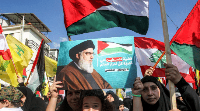 Palestinian, Lebanese and Hezbollah flags are waved during a rally against Israel in Nabatieh, southern Lebanon