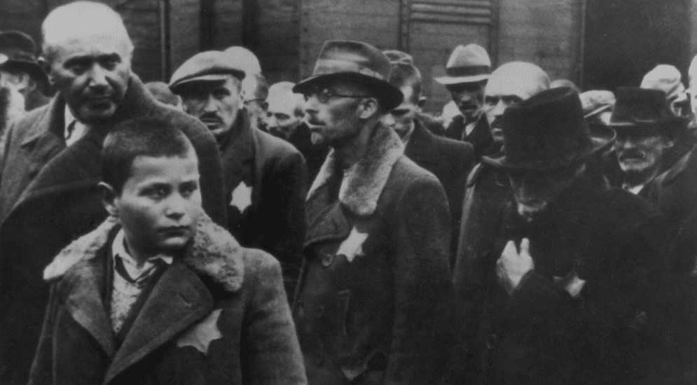 Jewish deportees, with the yellow stars sewn on their coats, arriving at Auschwitz in May 1944