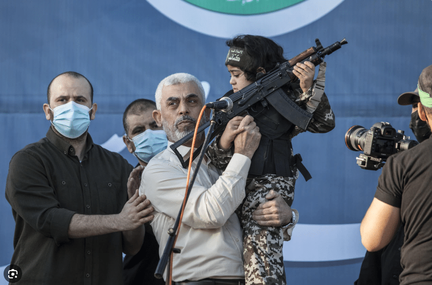 Leader of Hamas military wing, holding toddler with assault rifle